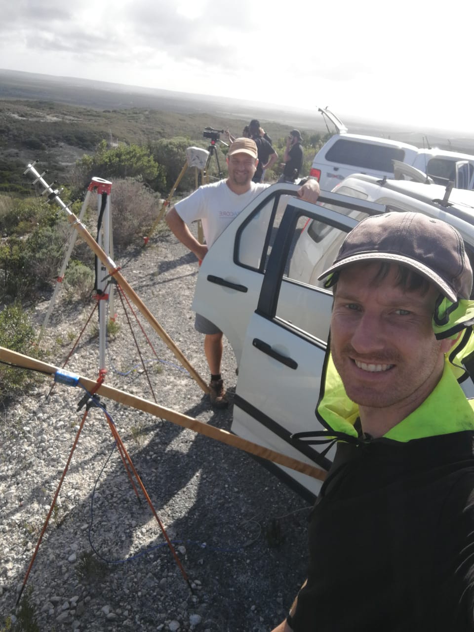 Two people tracking a rocket flight from the field with antennas