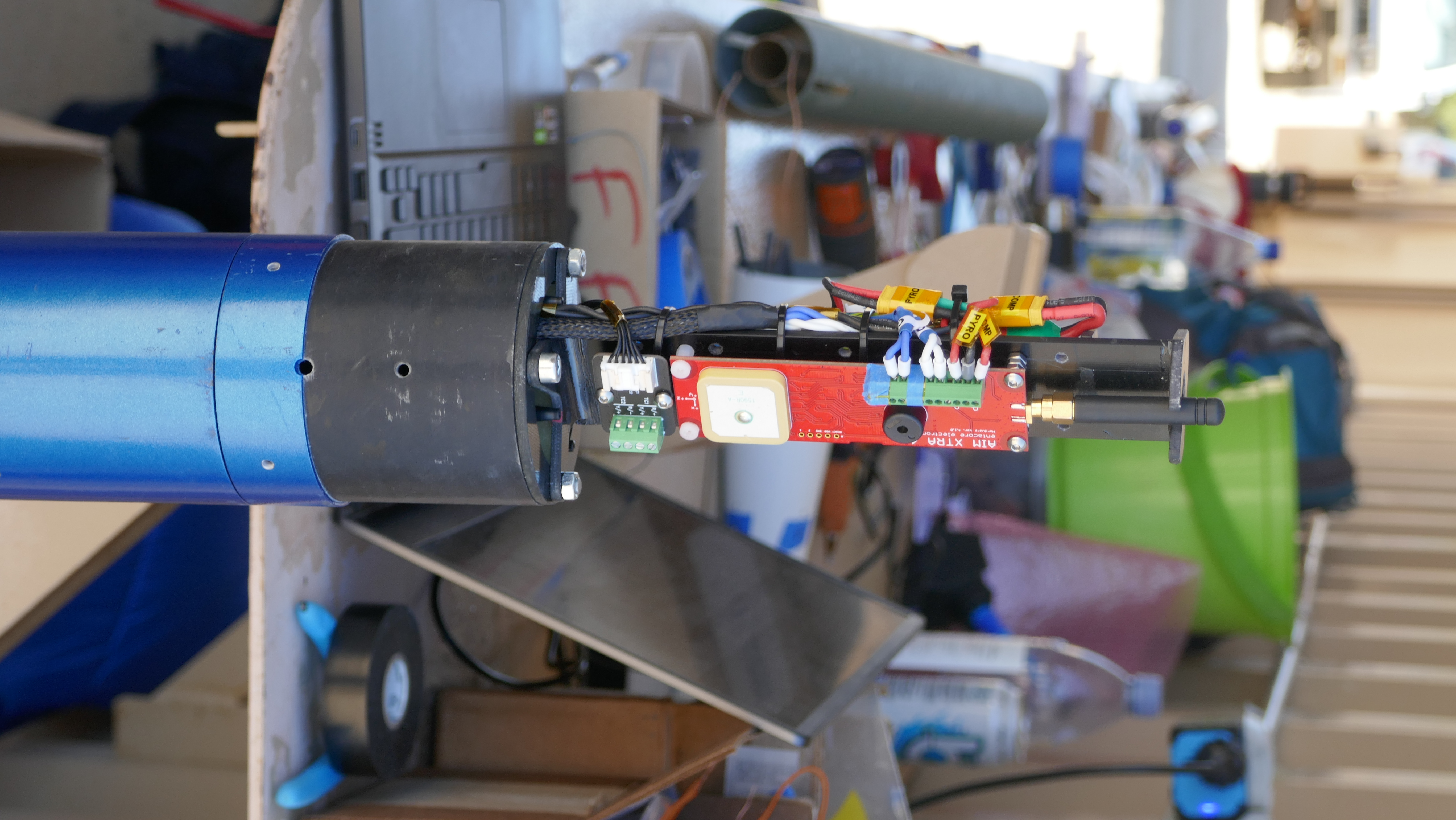 AIM XTRA mounted in a customer avionics bay on a blue airframe coupler
